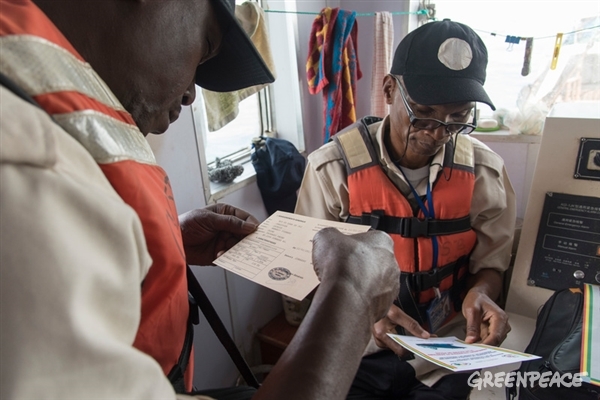 Guinean fishery inspectors on board Chinese fishing boat FU YUANG YU 362, checking licence and documents during a joint high sea operation with Greenpeace.