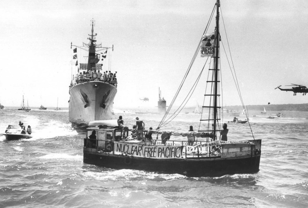 The USS Pintado submarine, escorted by the HMNZS Waikato (the same frigate sent to Moruroa test zone in 1973 by the New Zealand Government), is met by the Peace Squadron as it arrives in Waitemata harbour, Auckland in 1978. The vessel in the foreground is the Alliance - a scow which was part of the Peace Squadron. The growing anti-nuclear movement in New Zealand was hostile to visits from US ships because the Americans refused to confirm or deny whether their ships carried nuclear weapons. Public opinion was increasingly in favour of banning these visits. Between 1978 and 1983 opposition to nuclear-armed ship visits rose from 32% to 72%. In 1985 the Government effectively banned nuclear ship visits. New Zealand was the first country to declare itself nuclear free when it passed legislation in 1987. © Greenpeace