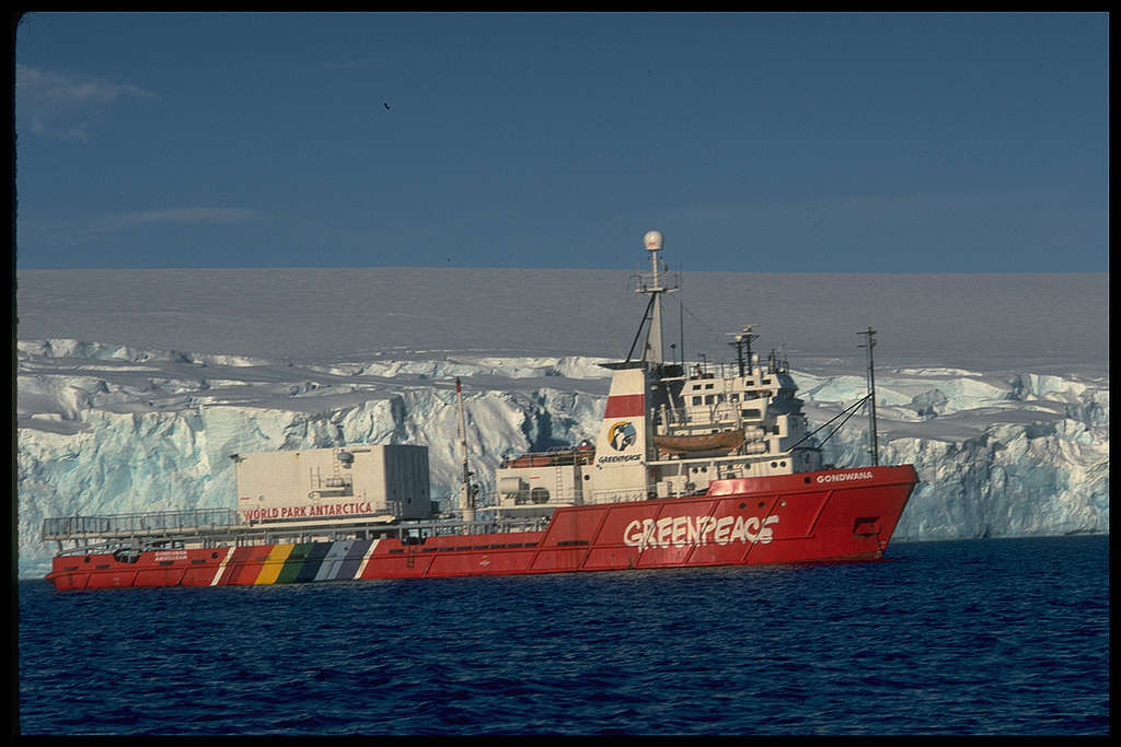 Side view of MV Gondwana, iceberg behind the ship. Arthur Harbour, near Palmer Station (US). © Greenpeace / Robin Culley