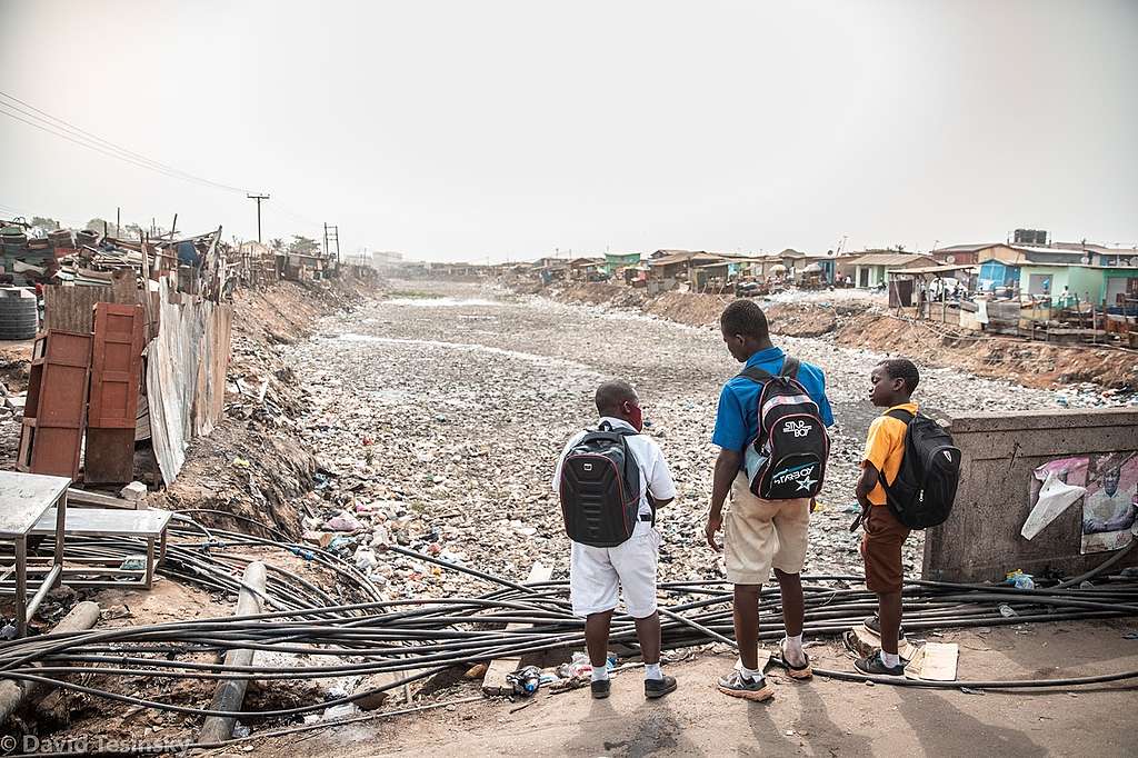 School children in Ghana look over plastic waste © David Tesinsky