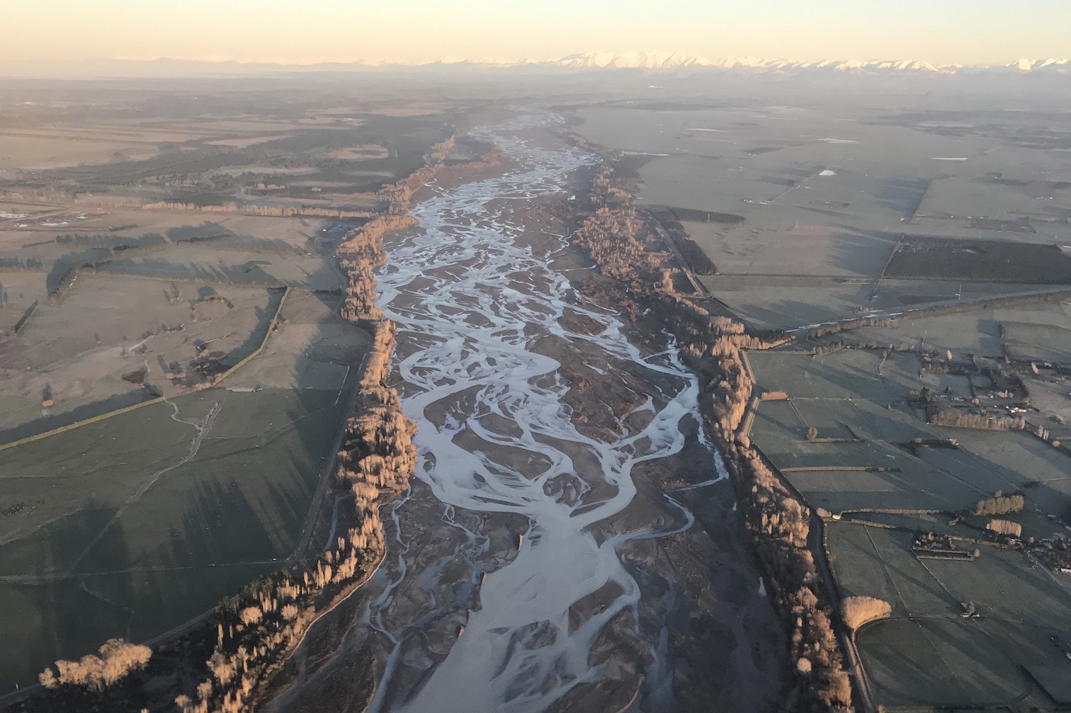 an aerial view of a braided river at sunset