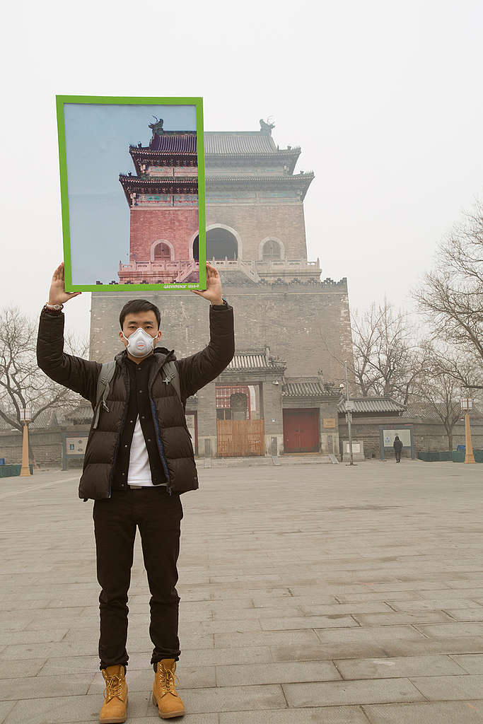 Wearing a protective face-mask, a Greenpeace activist shows "a piece of blue sky" in a photo he is holding whilst standing in front of China's historical building, the Bell Tower. Greenpeace urges the Chinese government to accelerate its efforts in reducing air pollution, including phasing out dirty industry and reducing coal consumption. Greenpeace also reminds people affected by smog to use proper personal protection.