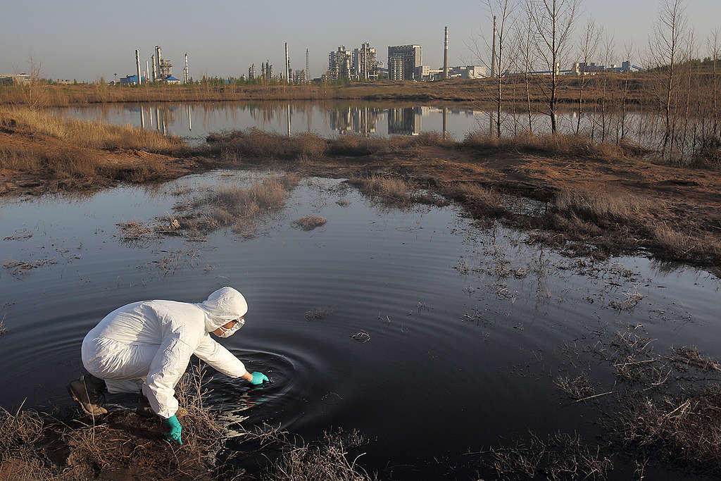 A Greenpeace investigator takes samples of waste water discharged by the Shenhua Coal-to-Liquid Project into a sand bank where it is left to seep into the ground and evaporate. For ten years, the Chinese state-run organisation Shenhua Group, has been exploiting water resources at a shocking scale from the Ordos grasslands to use in its coal-to-liquid project (a process for producing liquid fuel from coal) and illegally dumping toxic industrial waste water. Shenhua's operations have sparked social unrest and caused severe ecological damage including desertification, impacting farmers and herders who are facing reduced water supplies in what was once an abundant farming area.