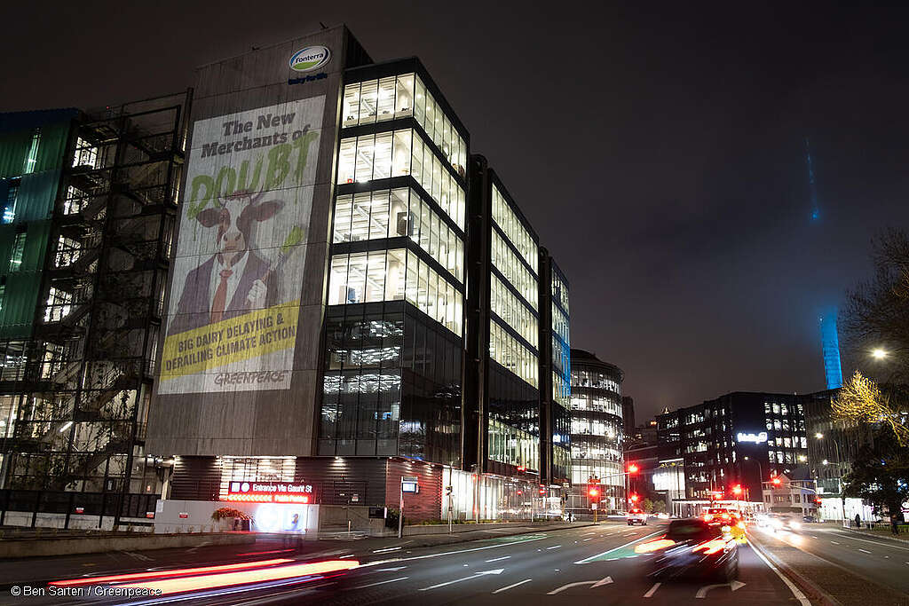 Greenpeace Aotearoa project a giant image on to the side of the Fonterra HQ in Auckland, New Zealand that reads “The New Merchants of Doubt - Big dairy delaying and derailing climate action.
