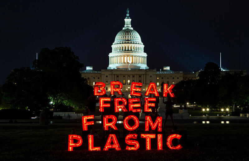 The words BREAK FREE FROM PLASTIC are lit up at night in front of the White House