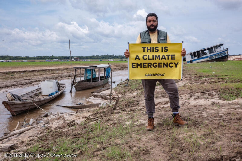 Activista sostiene una pancarta en el lago seco de Tefé para mostrar los impactos de una grave sequía en la zona.