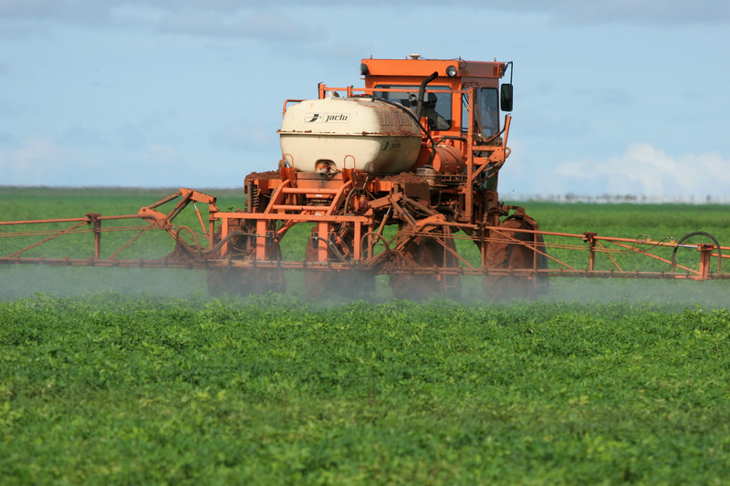 Trator pulveriza agrotóxicos em plantação de soja no Brasil