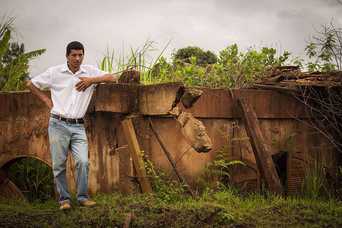 O apicultor Caé, ao lado de sua casa soterrada pela lama, em Bento Rodrigues.
