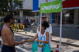 Ativista do Greenpeace oferece limonada ao professor de química Vinícius César Dias, no quiosque do Greenpeace na avenida Paulista