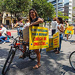 Cicloativista segura placa com os dizeres "Com dificuldade para respirar? Chega de emissões", na Avenida Paulista
