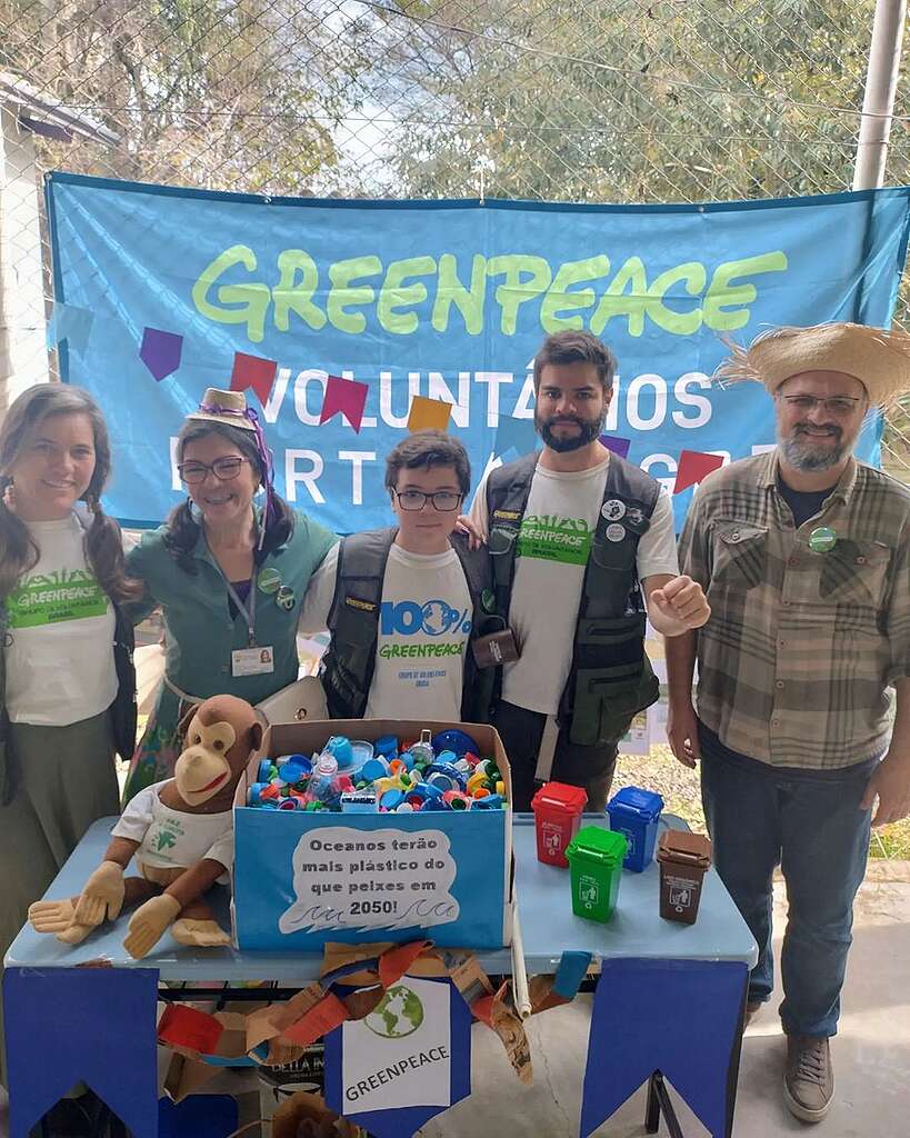 Pessoas voluntárias posicionadas em frente ao banner com texto "Greenpeace Voluntários Porto Alegre"
