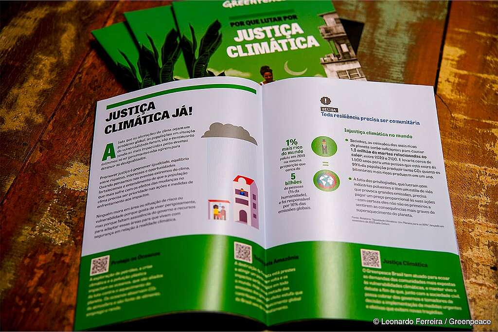o mapa impresso "Por que lutar por justiça climática" está aberto na primeira página.