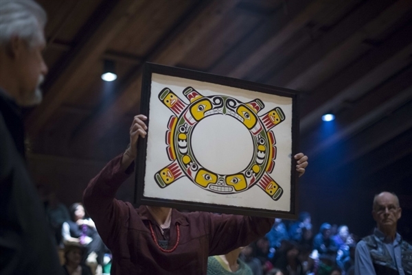 New Sisiutl Crest held aloft by Greenpeace staff Eduardo Sousa as Greenpeace foudners Rod Marining (left) and Bill Darnell (right) look on, at Willie Family Potlatch (Photo John Lehmann Globe And Mail)