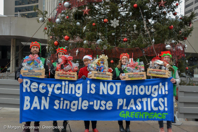 Greenpeace activists hold a sign reading "Recycling is NOT enough! BAN single-use PLASTICS!" before delivering plastic pollution "gift boxes" to Canada's five top polluting corporations – Nestlé, Tim Hortons, PepsiCo., The Coca-Cola Company and McDonald’s.