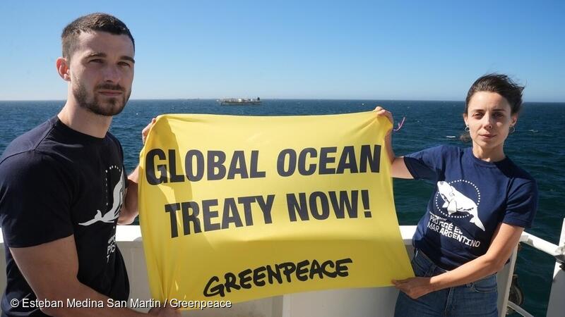 Greenpeacers holding the "Global Oceans treaty Now!" sign