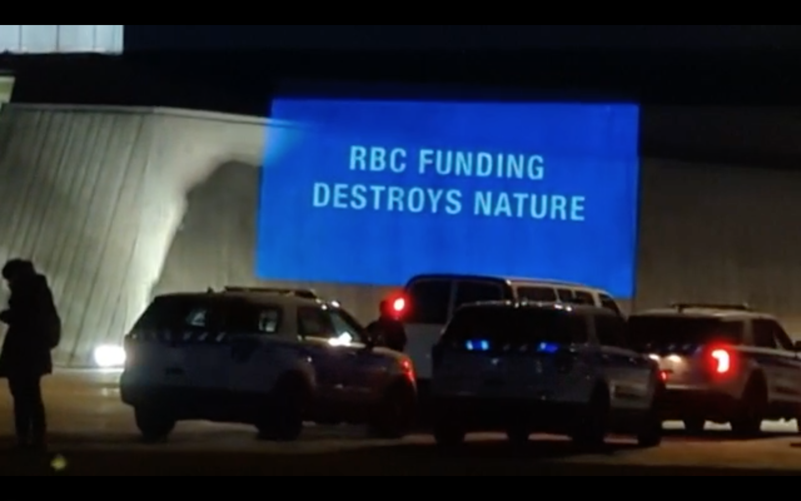 Night projection saying "RBC Funding Destroys Nature"