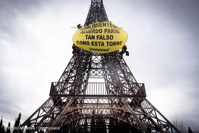 Réplica de la Torre Eiffel en Torrejón de Ardoz (Madrid) sobre la que hay colocado una pancarta gigante que dice "Cumplimiento del Acuerdo de París: tan falso como esta torre". 