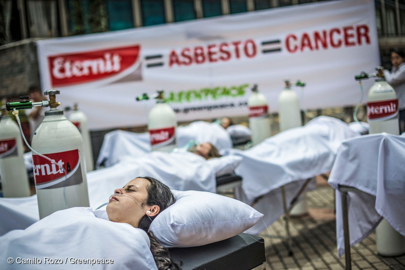 El asbesto enferma Colombia - 30 activistas caracterizados como enfermos desplegaron un banner en el centro de Bogotá para alertar sobre los efectos a la salud del asbesto y pedirle a Eternit que deje de fabricar y comercializar productos contaminantes. -
