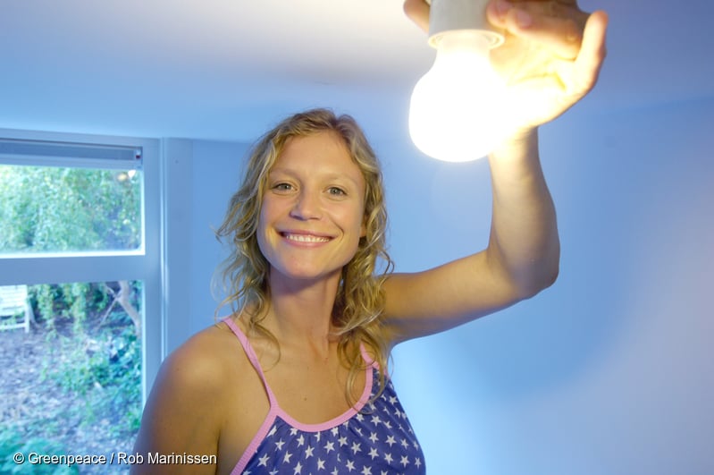 Mujer sosteniendo una lámpara de bajo consumo.