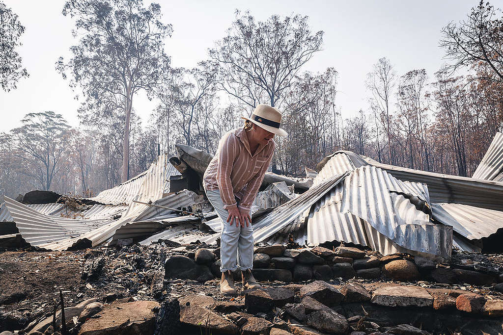 Melinda Plesman, která přežila požár, zkoumá škody na svém domově v obci Nymboida v Novém jižním Walesu. © Natasha Ferguson / Greenpeace