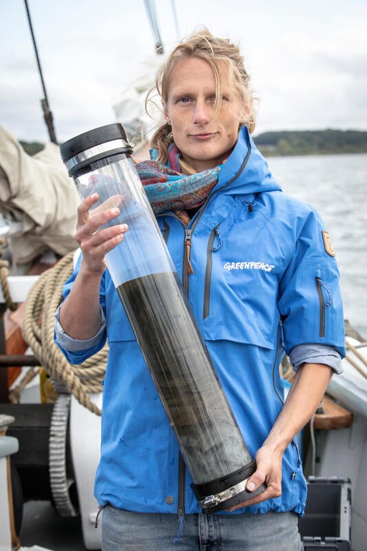 Greenpeaceaktivist holder en prøve af Det Sydfynske Øhavs døde havbund