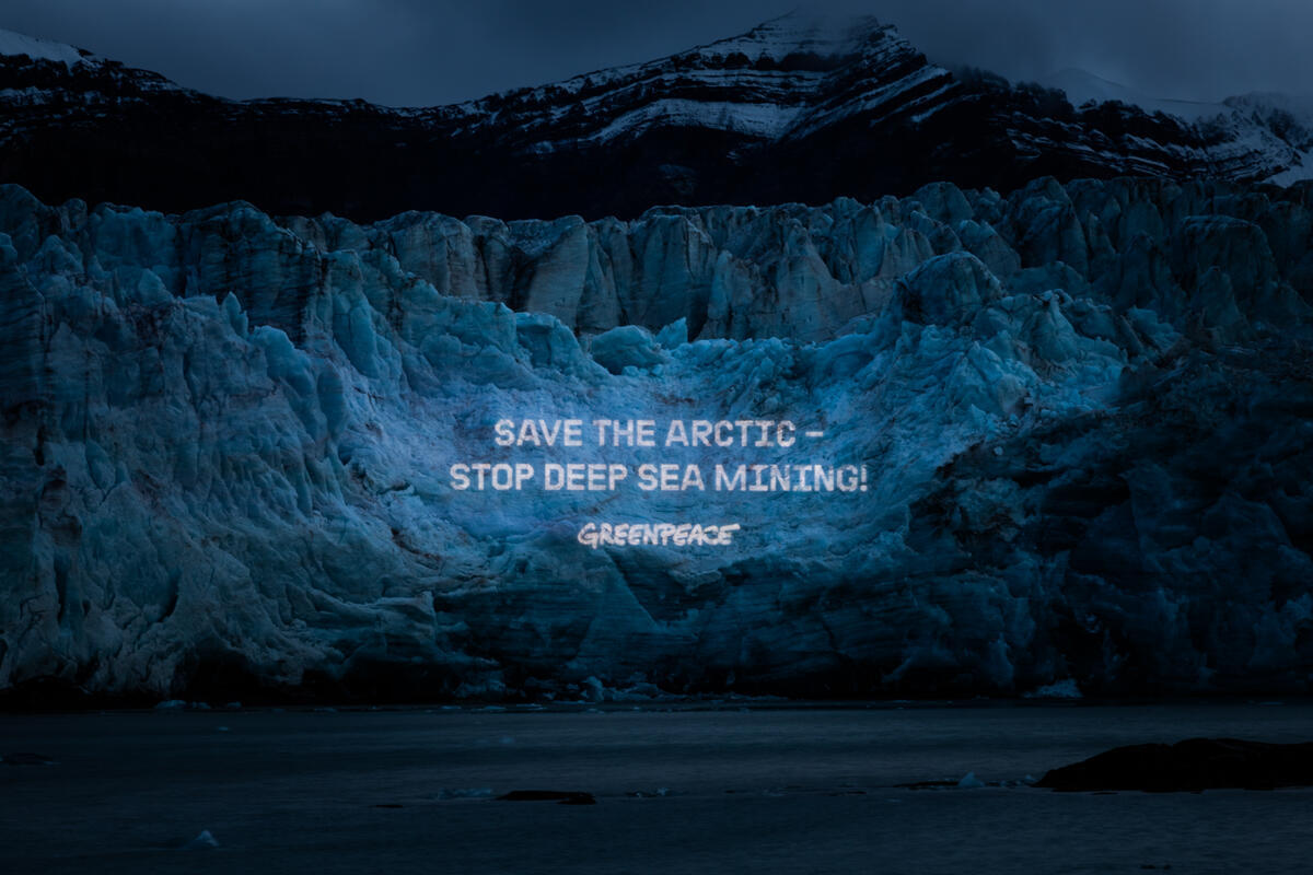 På turen til Arktis projekterede aktivister fra Greenpeace International, Nordic og Tyskland budskaber op fra folk, der er imod minedrift på havbunden. Her er det budskabet “Save The Arctic - Stop deep sea mining!” som er projekteret op på Svea-gletsjeren i Svalbard © Bianca Vitale / Greenpeace