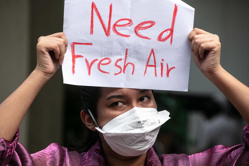 Mielenosoittaja pitelemässä kylttiä, jossa lukee "Need Fresh Air".