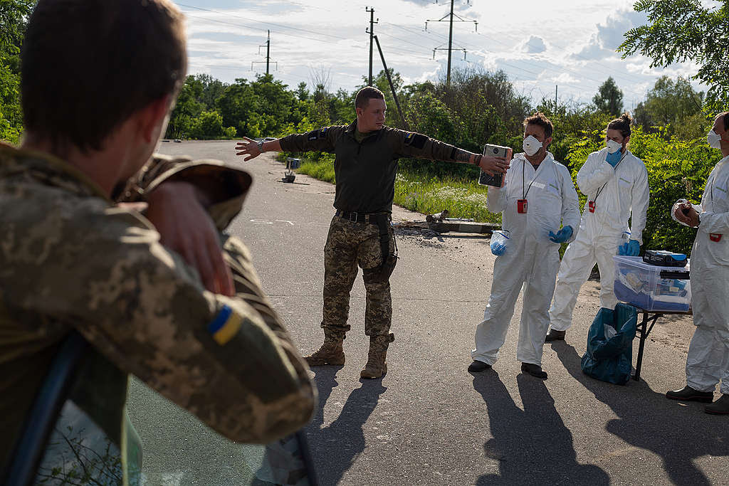 Greenpeacen mittausryhmä mittaa ukrainalaissotilaan säteilyarvoja.