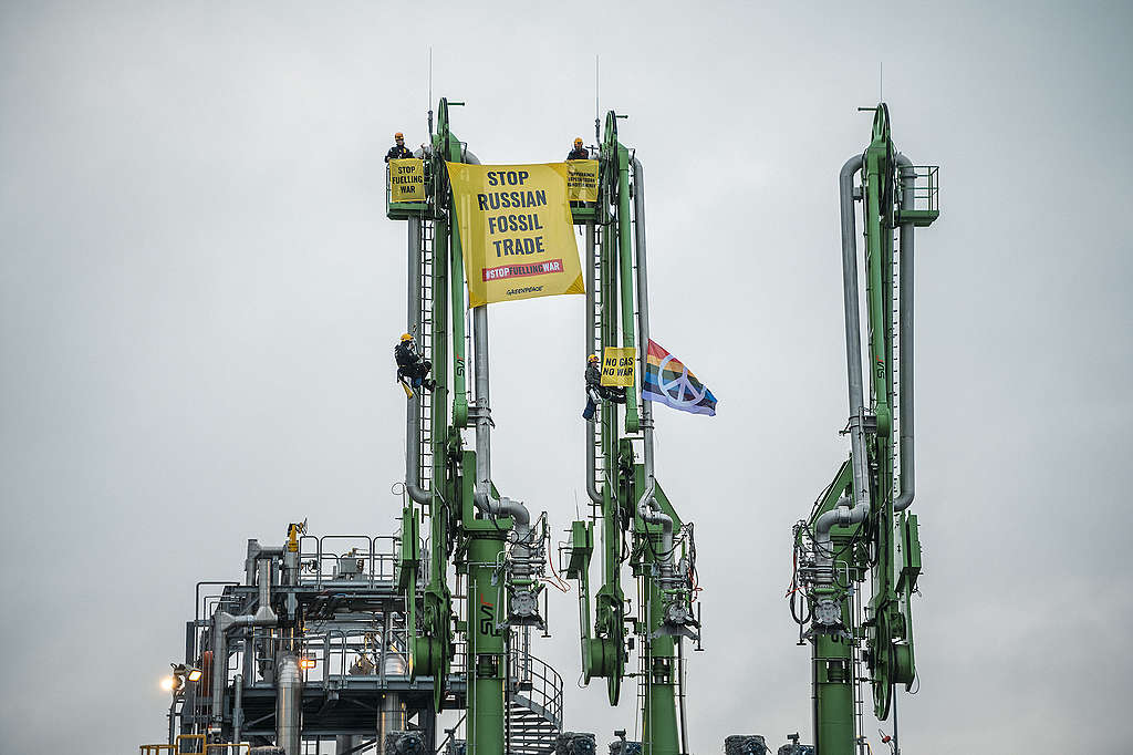 Kiipeilijöitä banderollien kanssa Röyttän sataman lastausvarsissa. Banderolleissa lukee esimerkiksi "Stop Russian fossil trade"