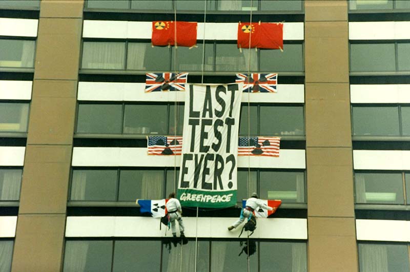 27 January 1996: Greenpeace activists abseil down to the 8th floor of the building housing the French Embassy in Wellington to hang a large that reads “Last Test Ever?” The 46-kiloton explosion carried out at Fangataufa Atoll near Moruroa Atoll in Te Ao Maohi/French Polynesia was a detonation of the 110-kiloton TN 75 thermonuclear warhead for France's M45 submarine-launched ballistic missile, which has a flight range of 6,000 kilometres. Photo: Rob Taylor