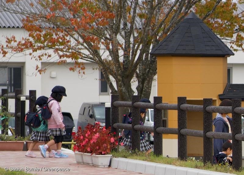 Children leaving new kindergarten in Iitate, Fukushima prefecture. Iitate, which lies 30-45km northwest of the Fukushima Daiichi nuclear plant, was heavily contaminated by radioactive fallout in 2011. The Japanese government lifted the evacuation order for most of Iitate in March 2017. Greenpeace radiation surveys in the this area from 2015 and up to October 2018, show levels of radiation, particularly in the forested areas, remain high and above international safety maximum limits. This is despite a massive decontamination program by the Japanese government. Seventy percent of Iitate is mountainous forest which cannot be decontaminated. United Nations human rights experts, and the Committee on the Rights have the child have called for the government to comply with their obligations to protect children, including from harmful radiation. This includes setting a maximum limit for public exposure, including children, to 1 miliSievert per year (1mSv/y), not the current 20mSv/y - twenty times the recommended maximum set by the International Commission for Radiation Protection. Shaun Burnie/Greenpeace.