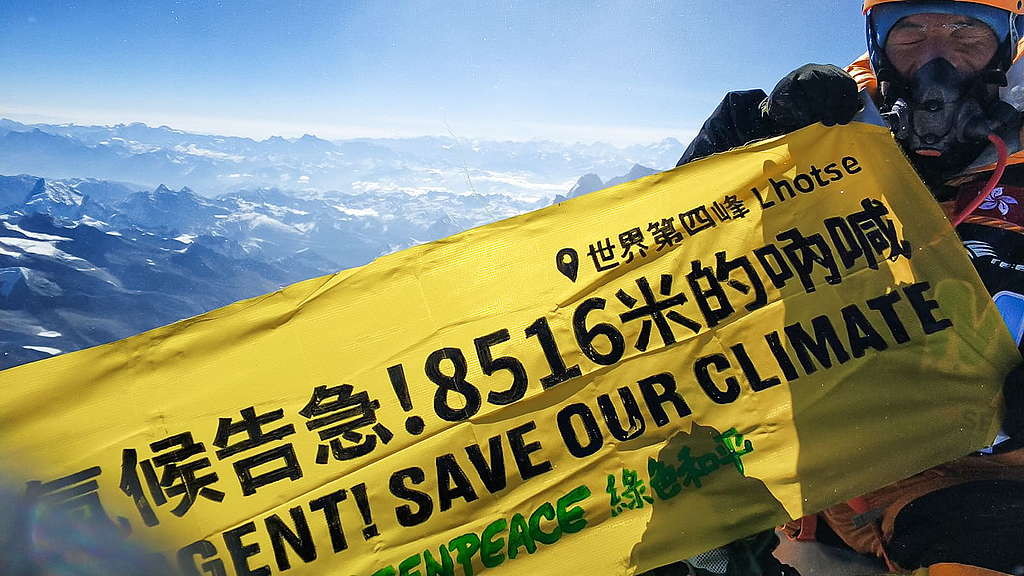 阿建在洛子峰頂拉起橫額，呼籲大眾正視氣候危機。 © Greenpeace