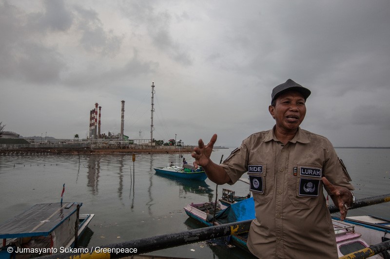 Margasari subdistrict chief, Ride, stands near the fishermen's boat that is docking on the water contaminated by oil next to Pertamina's refinery installation in Margasari village, Balikpapan Bay, East Kalimantan. An oil spill off Balikpapan bay in Borneo island that led to five deaths and the declaration of a state of emergency was caused by a burst of undersea pipe belongs to Indonesia's state oil company Pertamina
