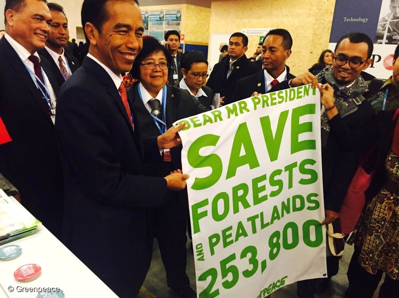 Indonesian President Joko Widodo, left, receives the petition banner from Greenpeace activists during the 21st Conference of Parties (COP21) at Stade de France in Paris, France, Nov.30, 2015. The petition is already signed by more than 253,800 people urging the President to save forest and peatlands in Indonesia. (Photo Greenpeace)