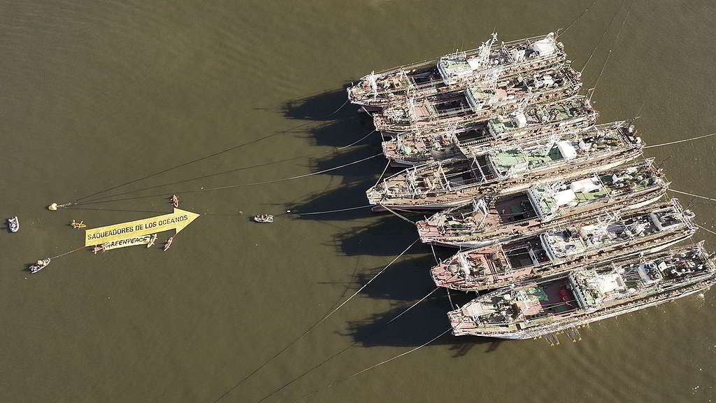 綠色和平行動者於蒙特維多港口發起直接行動，拉起一幅25米長橫額，把「海洋掠奪者」（Ocean Looters）矛頭直指以破壞漁法掏空當地海洋資源的超過400艘漁船。 © Fernando Garcia / Greenpeace