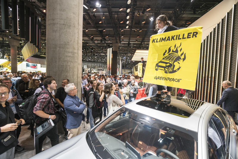 德國總理默克爾到訪國際車展期間，綠色和平連同其他行動者抗議使用柴油和汽油引擎的汽車破壞全球氣候。©Greenpeace