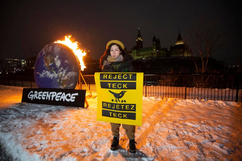 學生行動者於2月18日在加拿大國會山莊外，希望迎接聯邦內閣大臣回到下議院，手持「阻止泰克（能源公司）」的標語，背後是燃燒中的地球裝置，以顯示世人已經不能再承受繼續甚至擴大化石燃料開採的致命結果。© Greenpeace