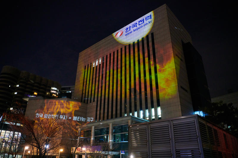 綠色和平在韓國電力公社（韓國最大的電力公司）的大樓，以光影投射，呼籲喝停海外煤炭投資。© Jung-geun Augustine Park / Greenpeace
