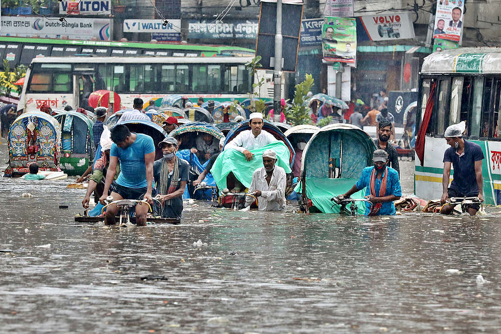 2020年7月21日，孟加拉首都達卡（Dhaka）因大雨造成淹水，行人與車輛在水深及腰的道路上前進。© Sk Hasan Ali / Shutterstock.com