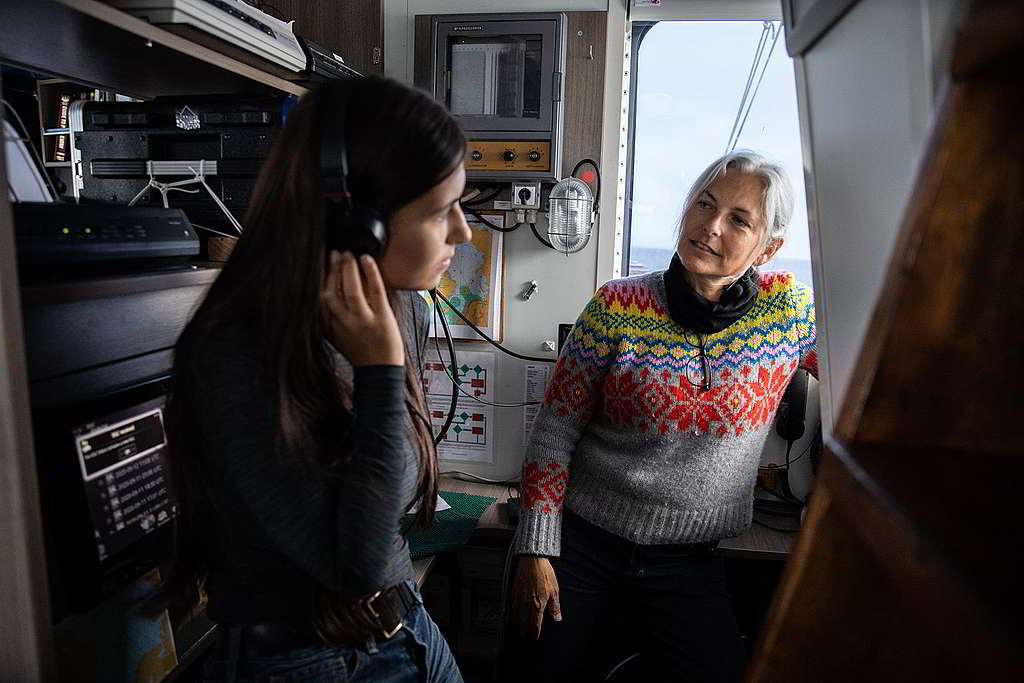 年僅18歲的氣候行動者Mya-Rose Craig（左），在科學家Kirsten Thompson指導下以水聽器（hydrophone）追尋鯨魚與海豚聲蹤。 © Daniella Zalcman / Greenpeace
