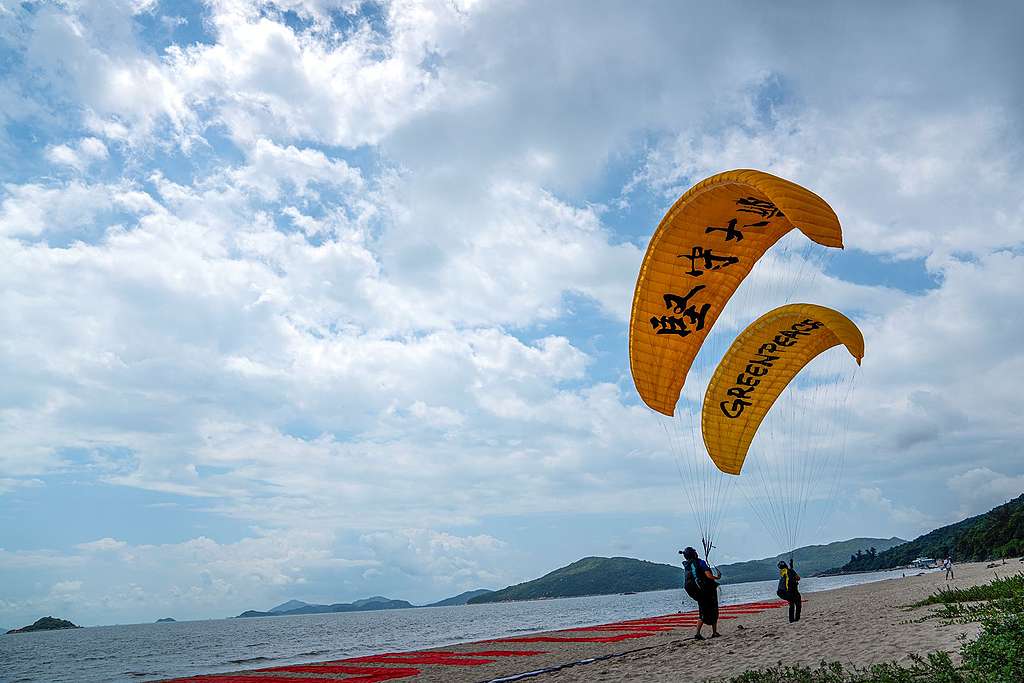 滑翔傘順利降落，但守護大嶼的行動需要大家加油和堅持！© Vincent Chan / Greenpeace