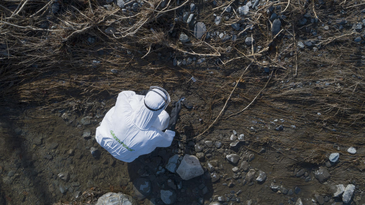 綠色和平檢測團隊穿上全身保護裝備，在福島縣緊靠太平洋的相馬市新田河（Niida River）河田採樣。© Christian Åslund / Greenpeace