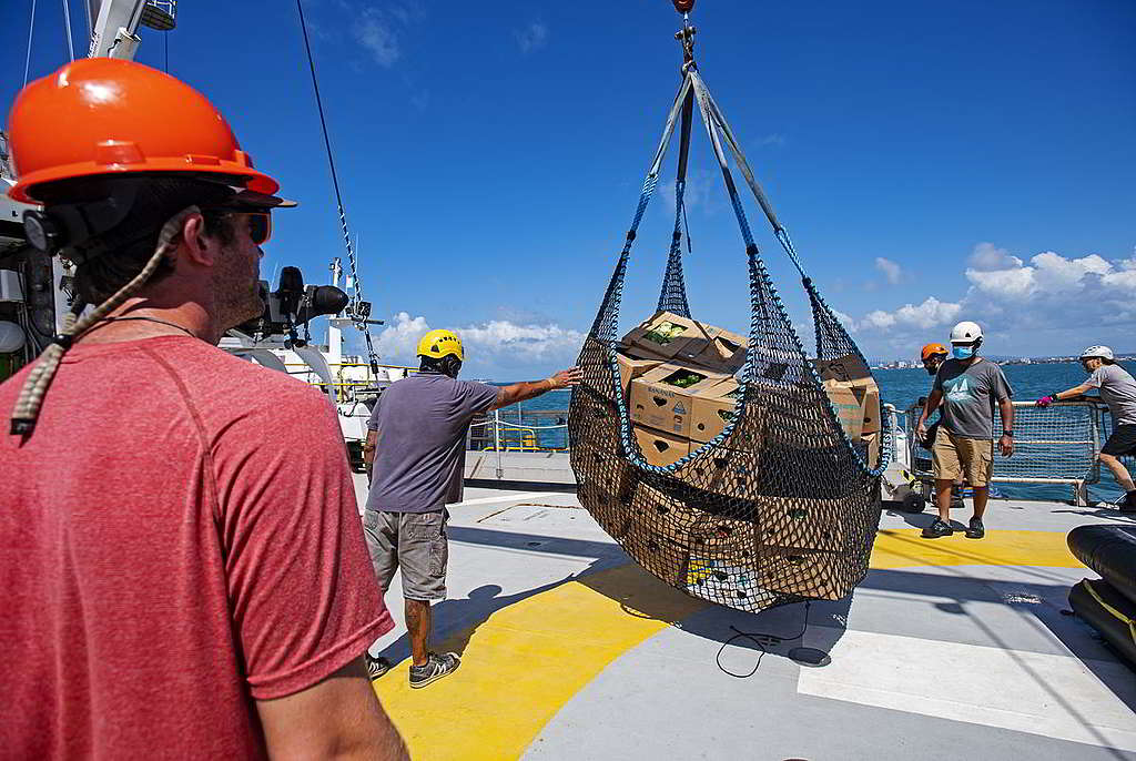 船員將食物從補給船上運送到彩虹勇士號，全員都要幫忙拆箱、搬運、收納3個月份量的食材。 © Marten van Dijl / Greenpeace
