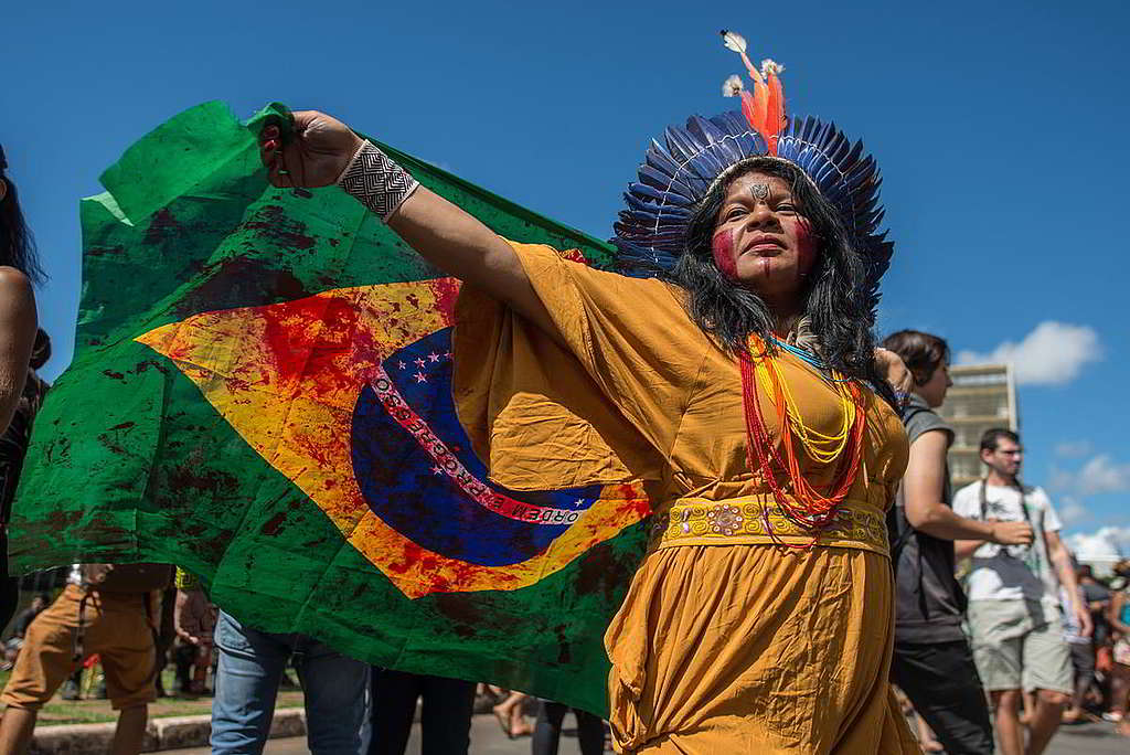 13：大自然這回事，對原住民（Indigenous Peoples）份外多一重「家園」的意義；而巴西亞馬遜森林原住民近年面對大火連場、土地掠奪及不公政策，可謂首當其衝的一群。2019年，部族領袖Sônia Guajajara等逾4,000位巴西原住民在首都巴西利亞遊行，促請當局保障應有權利；而綠色和平行動者則動員全球聲援，與站在守護環境最前線的他們同行。 © Christian Braga / MNI