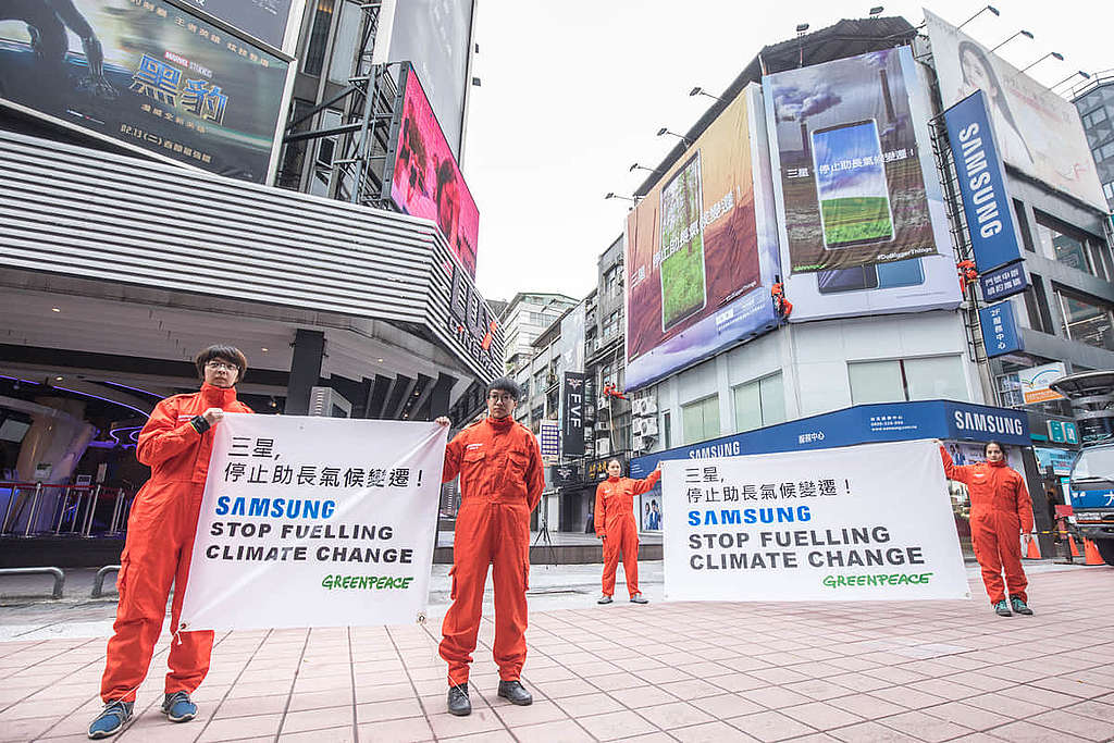 2018 年 1 月，綠色和平行動者在台北西門町的 Samsung 門市大樓外牆，掛上兩幅近 9 米長的巨型直幡，要求「三星，停止助長氣候變遷」。 © Chong Kok Yew / Greenpeace