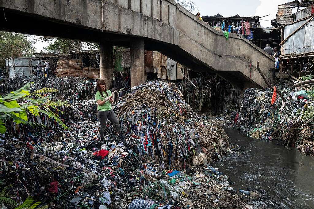 綠色和平團隊 2022 年前往肯雅調查被丟棄的速食時裝去向，在一個市集附近的河流發現大批紡織廢料堆積如山。 © Kevin McElvaney / Greenpeace