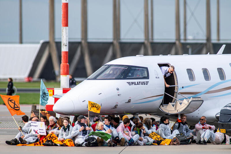 Az Extinction Rebellion és a holland Greenpeace aktivistái békésen tüntetnek az amszterdami Schiphol repülőtéren, amely az EU második legnagyobb légikikötője.
