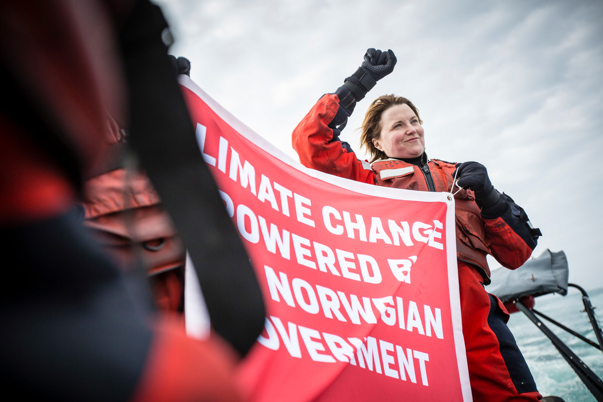 Actress Lucy Lawless holds up a banner reading “Climate change powered by the Norwegian government”. She joined other activists to oppose the Statoil Songa Enabler oil rig, 275 km North of the Norwegian coast, in the Arctic Barents sea © Will Rose / Greenpeace