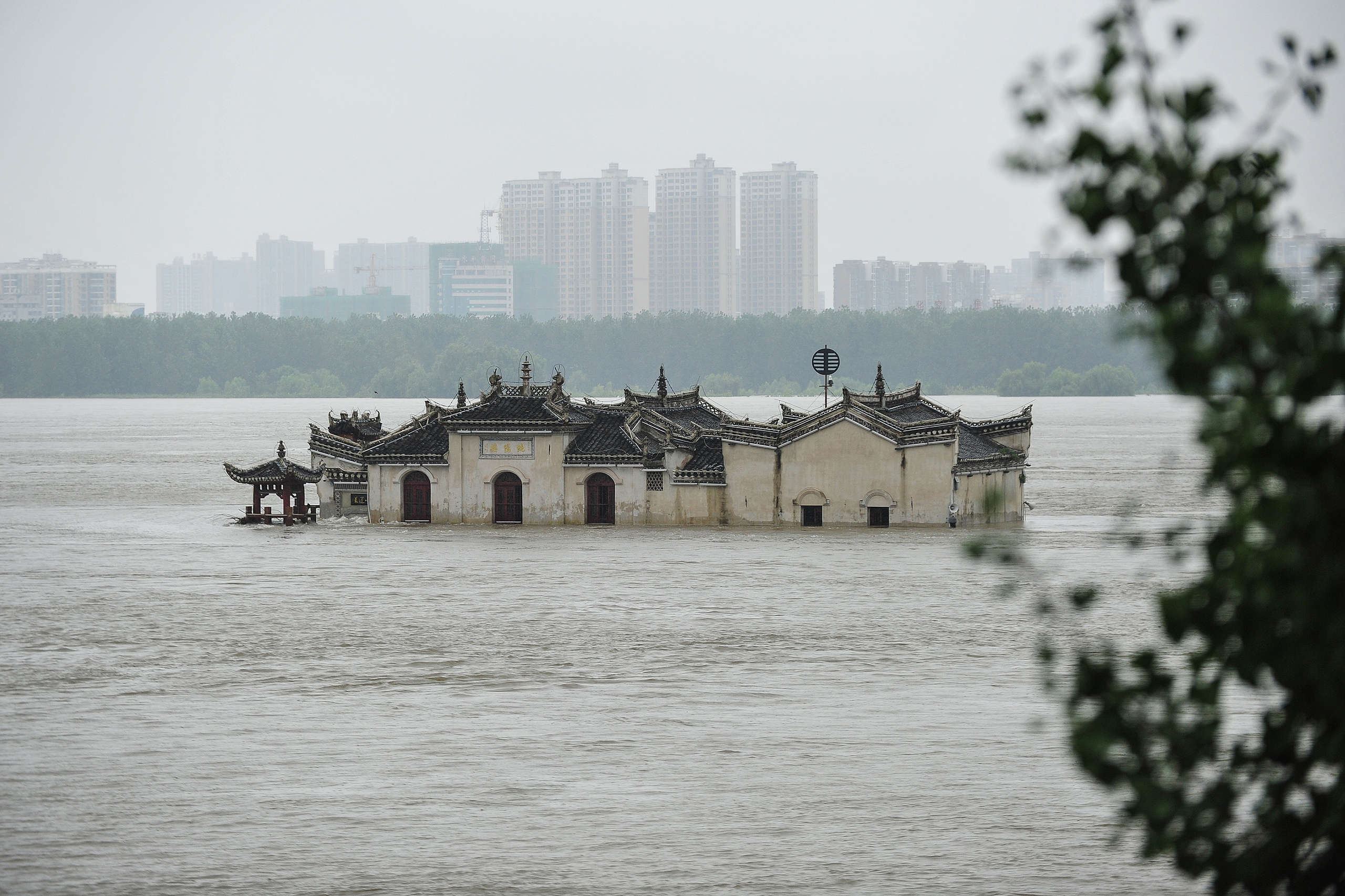 The Guanyinge temple, a 700-year old temple built on a rock, in the swollen Yangtze River in Wuhan in China's central Hubei province. - Heavy rains since June have left at least 141 people dead and missing, forced nearly 15 million people to be evacuated from their homes in July alone. © STR/AFP / Getty Images