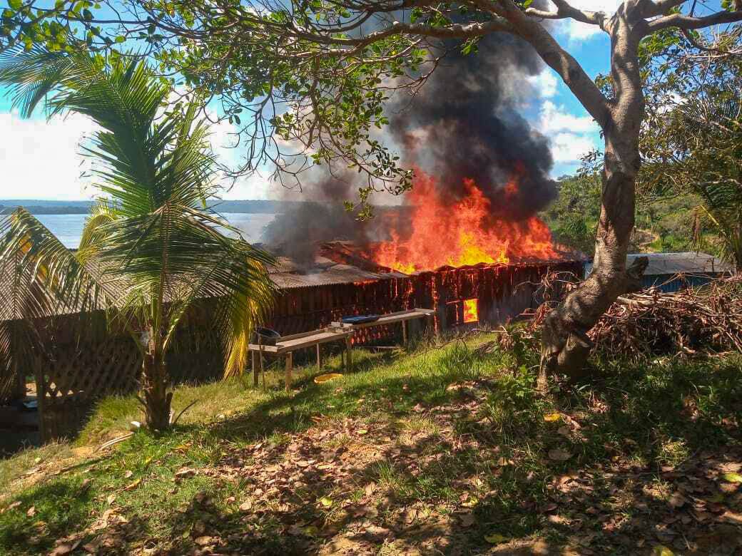 A building burns in a Munduruku village in the Amazon after an attack from illegal miners in May 2021.
